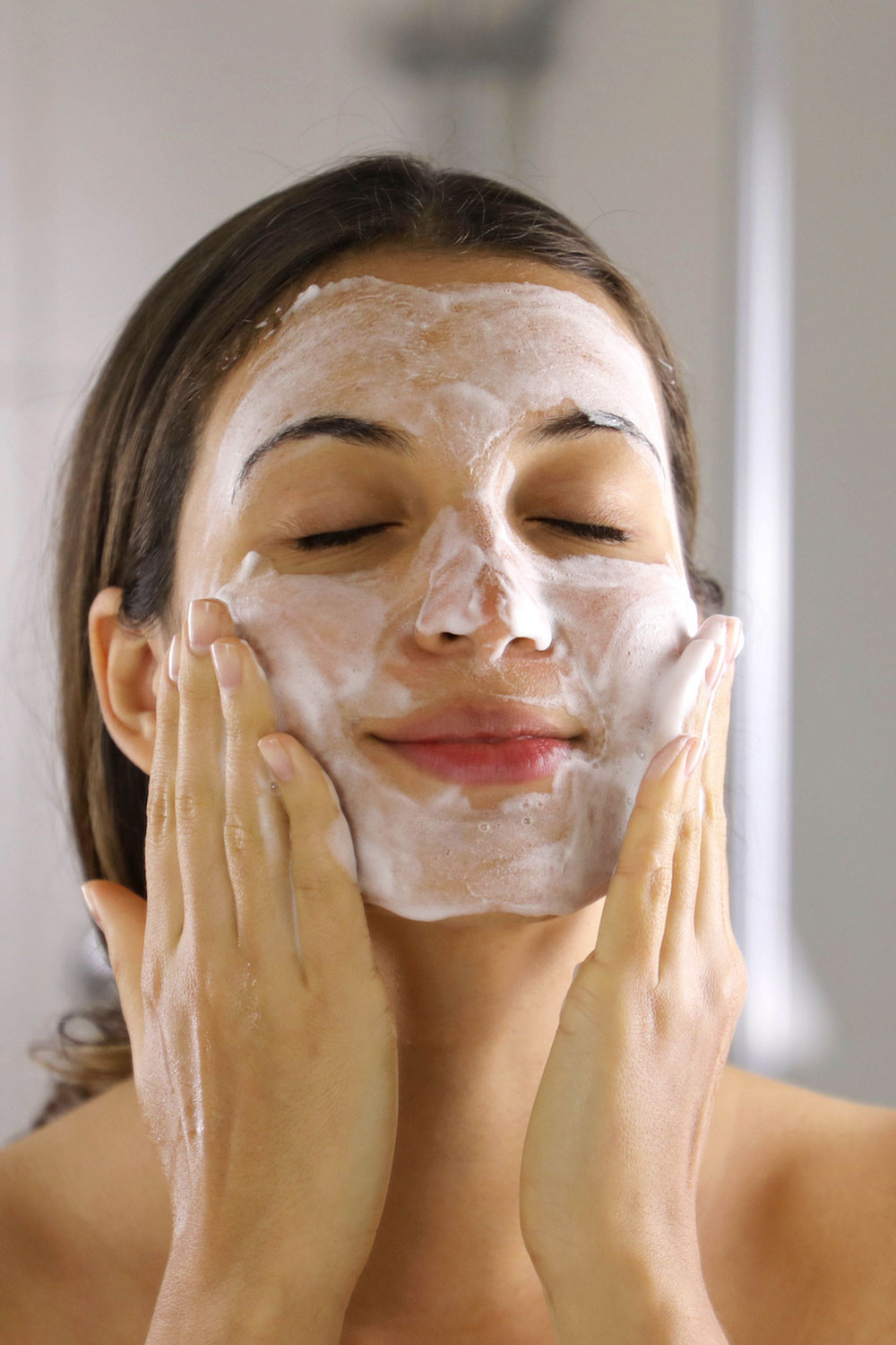 Female Gently Washing Her Face As Part of Microneedling Aftercare