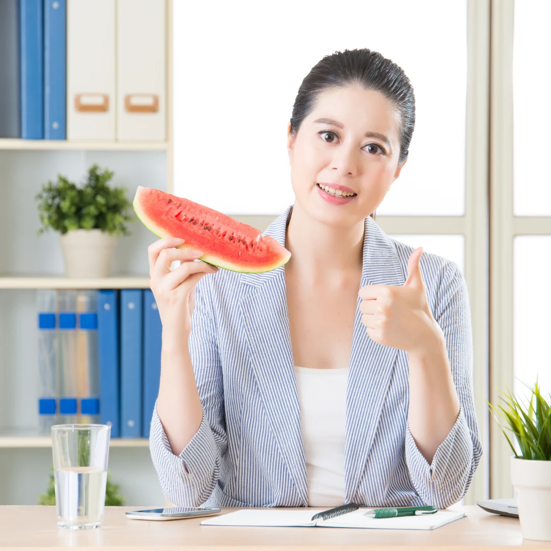 Asian Woman Showing Thumbs Up While Holding a Slice of Watermelon During Facelift Recovery